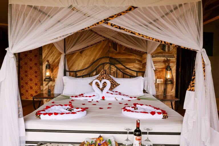Elegant interior of a luxury tent at Serengeti Sound of Nature, featuring a king bed, wooden furniture, and en-suite bathroom.